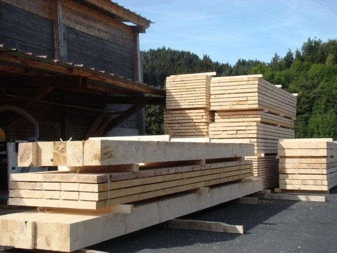 Piles de bois sciés devant le hangar de la scierie